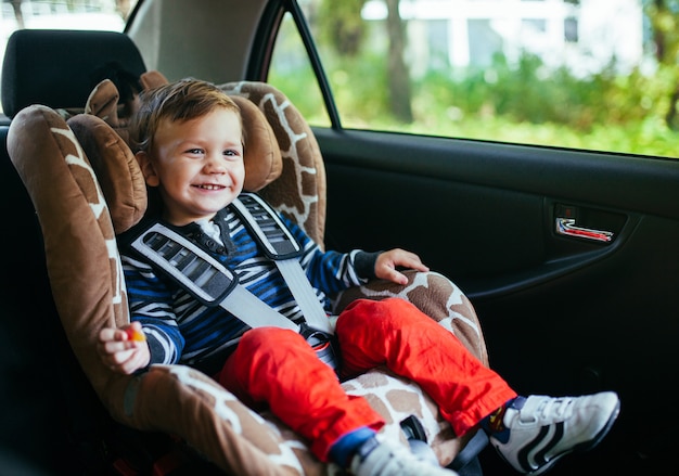 Adorable baby boy in safety car seat. 