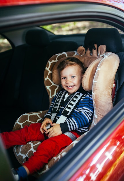 Adorable baby boy in safety car seat. 