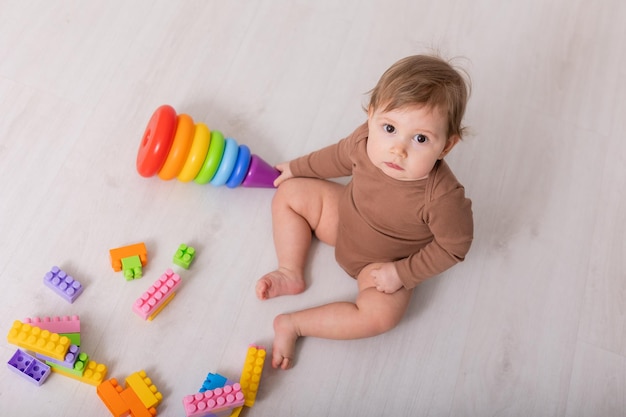 adorable baby in brown shirt playing with toys card banner space for text