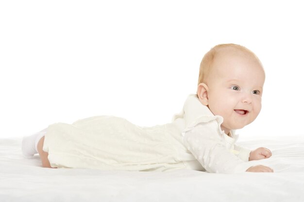 Adorabile bambina su una coperta su uno sfondo bianco