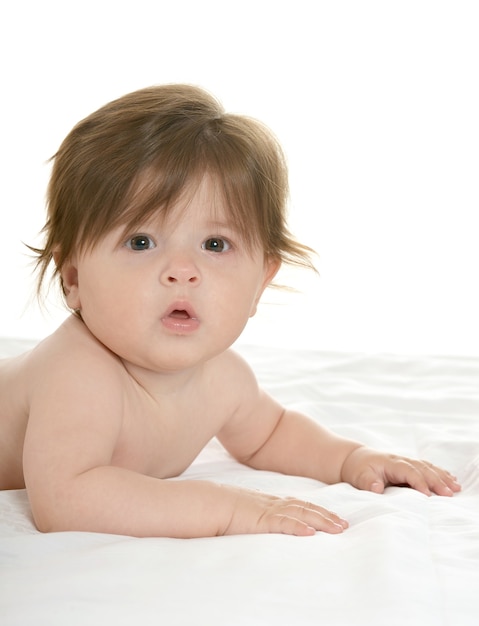 Adorable baby girl lying on a blanket on a white background