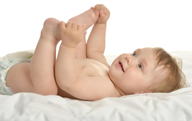 Adorable baby girl lying in pampers on blanket on a white background