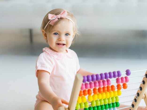 Adorable baby girl with educational toy scores in home