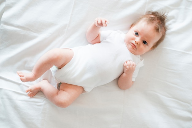 Foto adorabile bambino posa sul letto