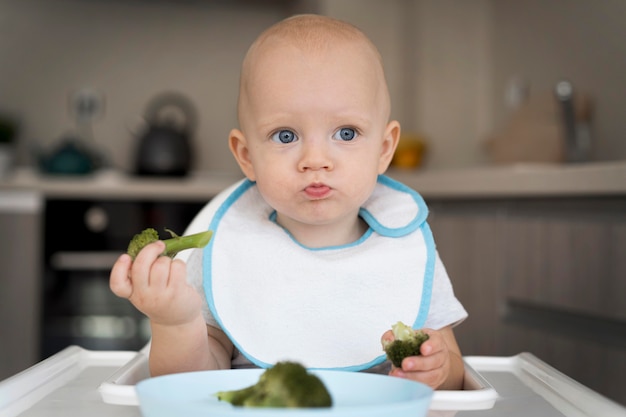 Adorable baby playing with food