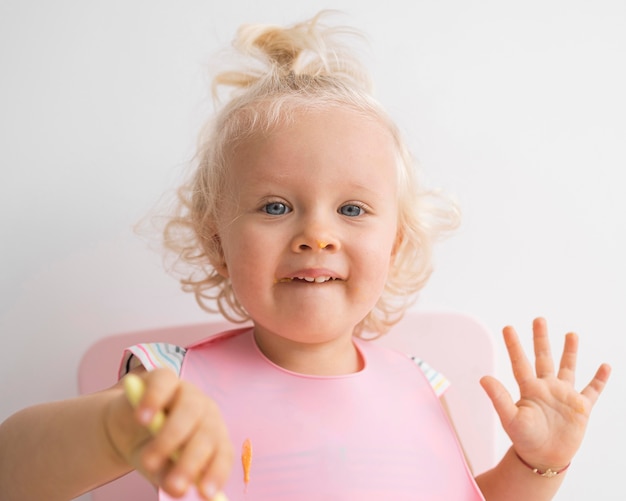 Adorable baby playing with food