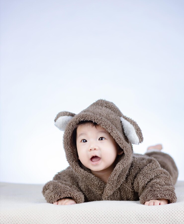 Photo 갈색 곰 의상을 입고 웃는 사랑스러운 아기
