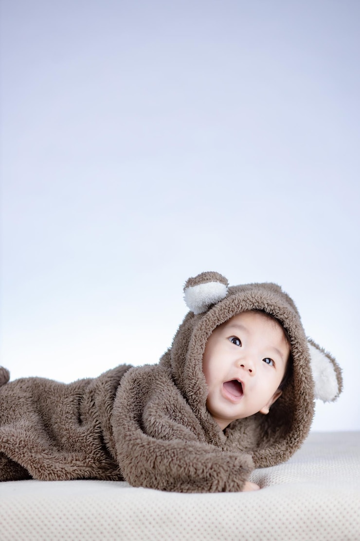 Photo 갈색 곰 의상을 입고 웃는 사랑스러운 아기