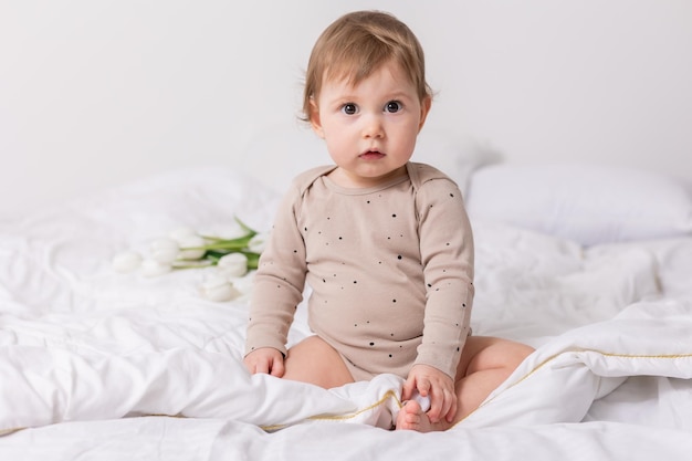 텍스트를 위한 담요 배너 공간에 흰색 튤립이 있는 사랑스러운 아기