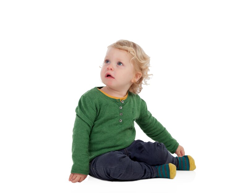 Photo adorable blond baby sitting on the floor