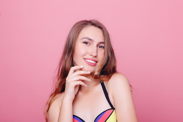 Adorable brunette in bikini posing on pink background