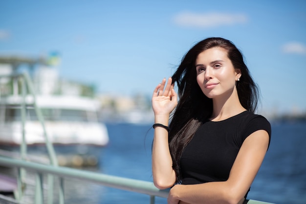 Adorable brunette model enjoying warm weather, posing at the river. Space for text