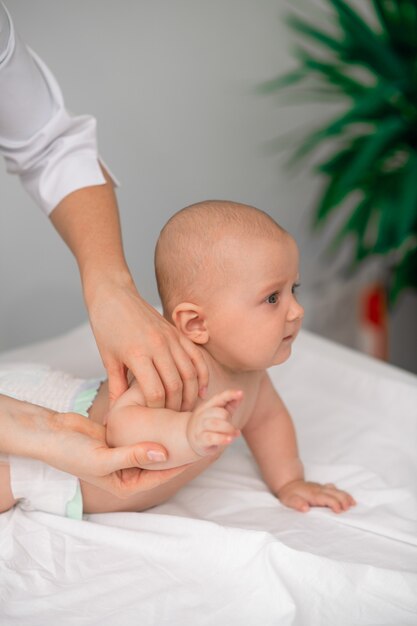 Adorable calm newborn child being examined by a qualified female pediatrician at a pediatric center