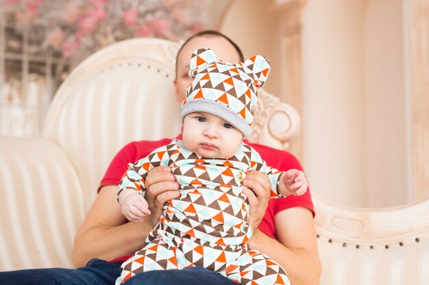 Adorable Caucasian baby and his father. Portrait of a three months old baby boy.