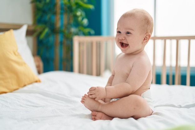 Adorable caucasian baby smiling confident sitting on bed at bedroom