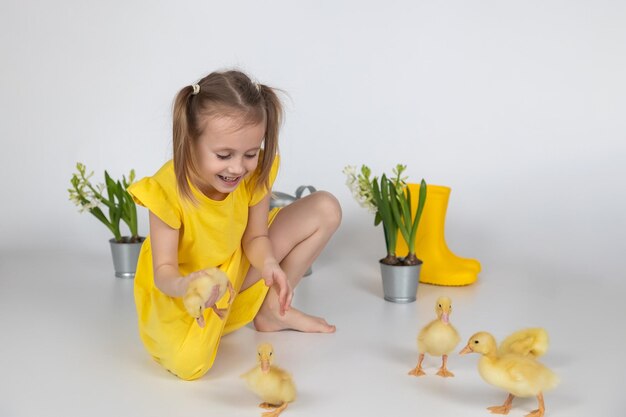 Adorable caucasian girl school age holding a cute duckling in the hands