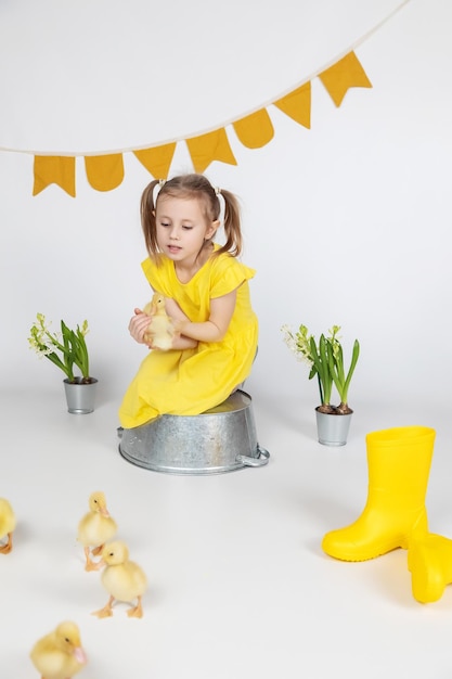 Foto adorabile ragazza caucasica in età scolare che tiene un simpatico anatroccolo nelle mani