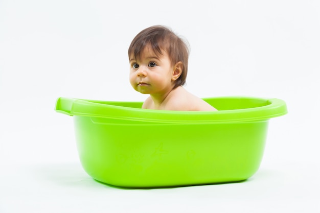 Photo adorable caucasian girl taking bath in green tub on white