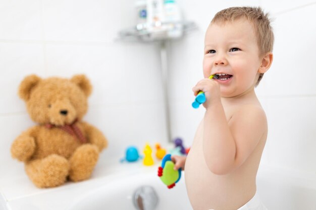 Adorable child learing how to brush his teeth