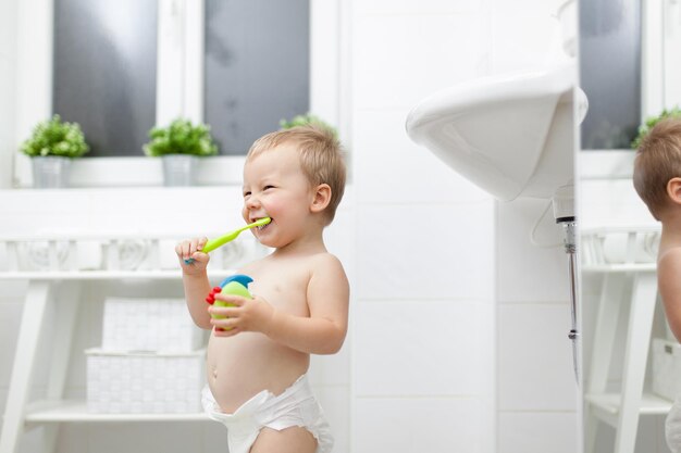 Photo adorable child learing how to brush his teeth