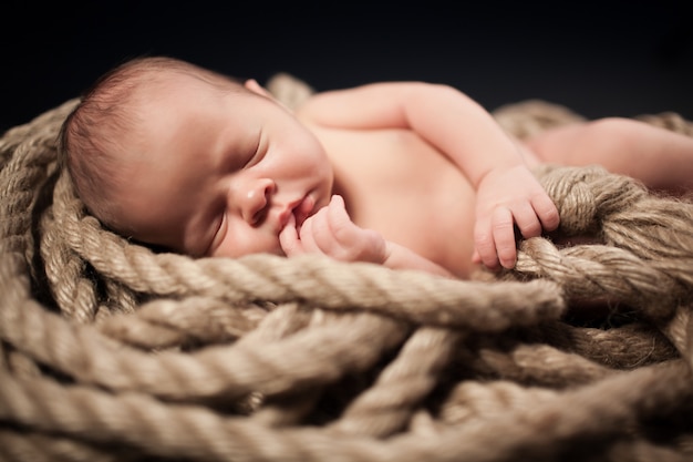 Adorable child sleeping among ropes.