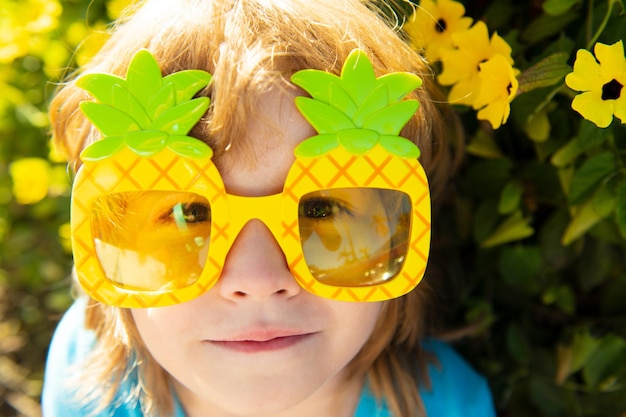 Adorable child in summertime with pineapple sunglasses Kid at sunny day outdoor with sun glasses