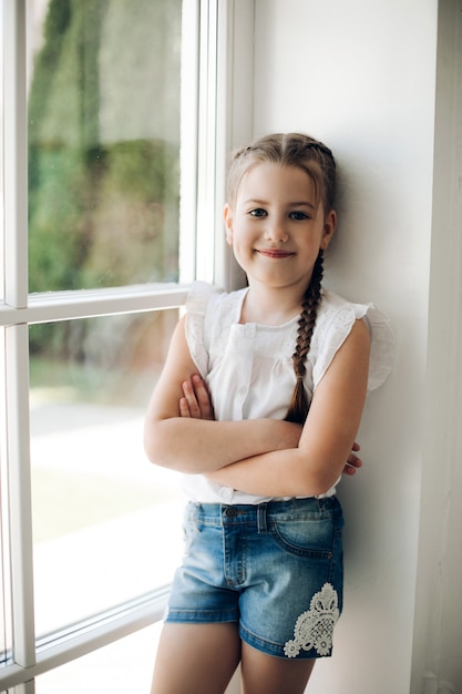 Adorable child with braid holding arms crossed on chest
