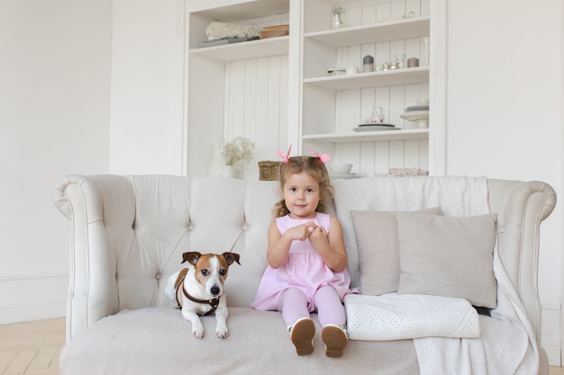 Adorable child with dog on sofa