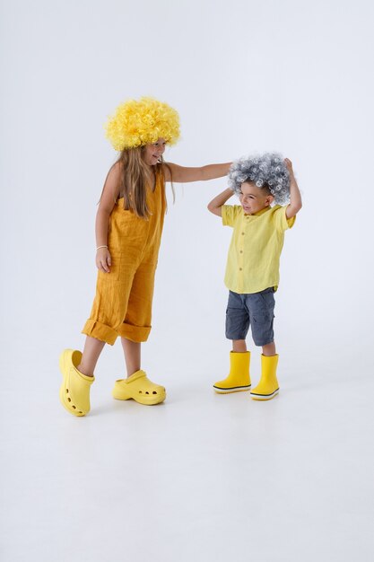 Adorable children in wigs having fun in studio