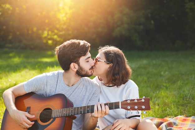 Adorable couple have passionate kiss, spend time outdoor on nature