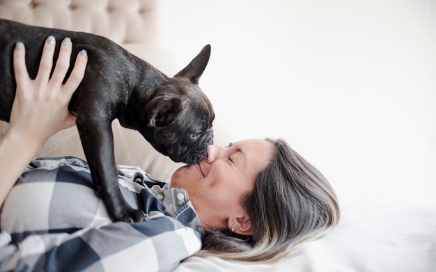 写真 愛らしい犬をなめる若い女の子