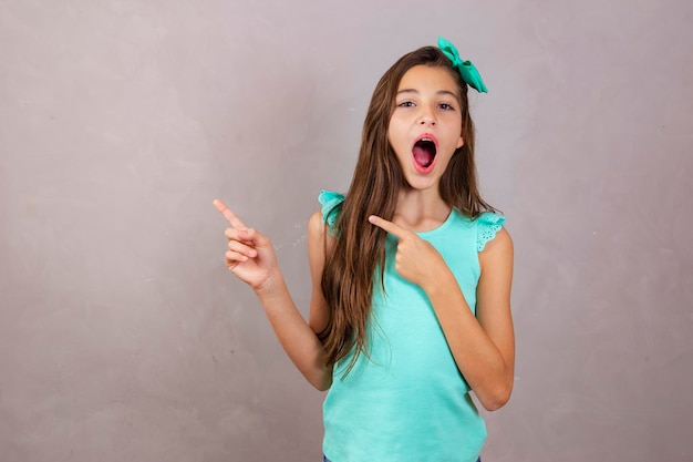 Adorable expressive girl pointing to the side