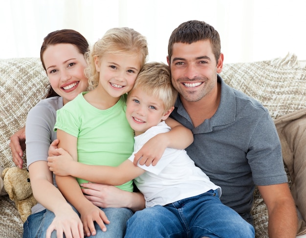Очаровательная семья, сидя на диване и улыбается
