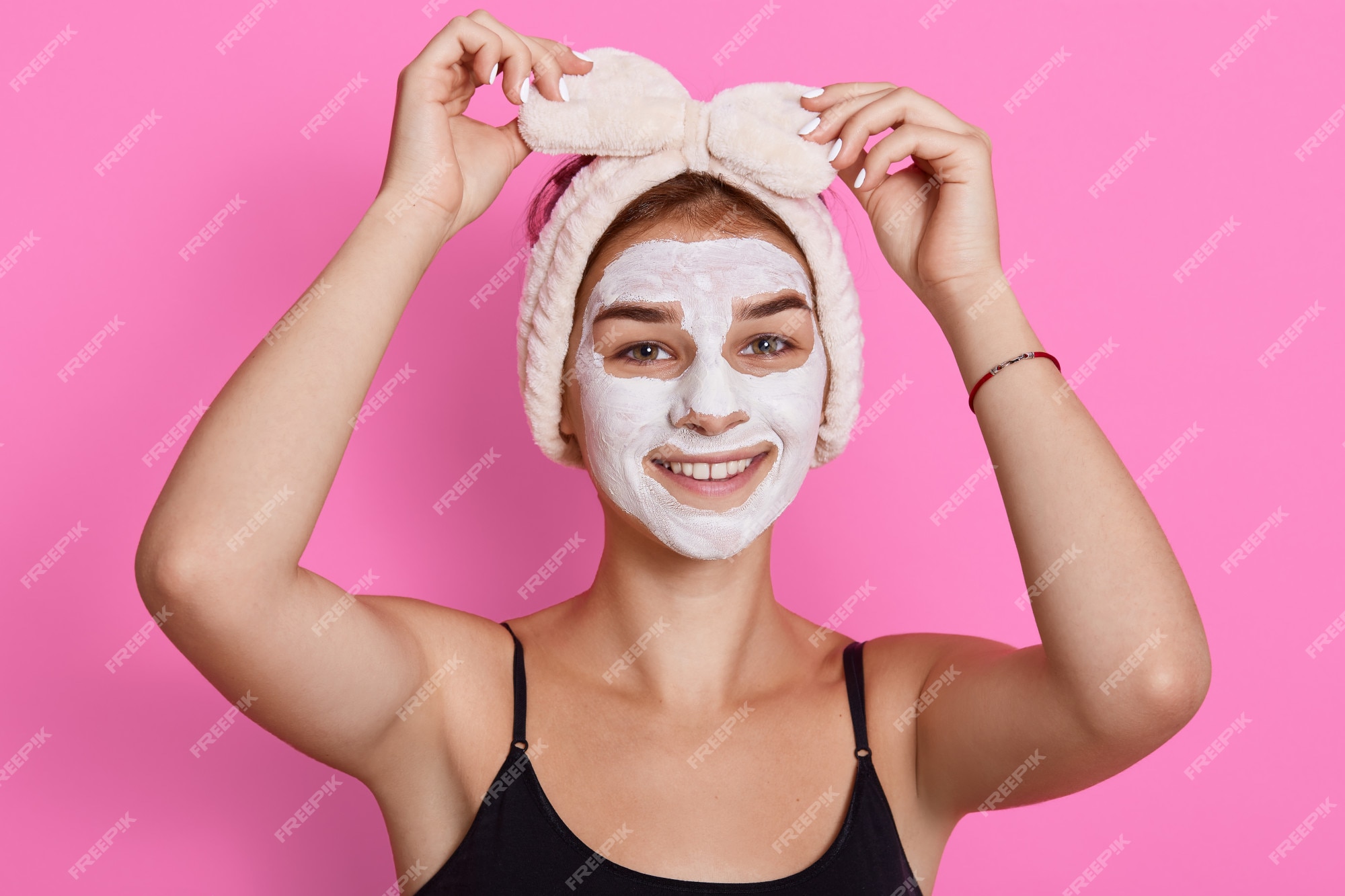 Premium Photo | Adorable funny woman with clay mask on her face and hair  band with bow on head touching her headband, has beauty procedures at home  in morning.