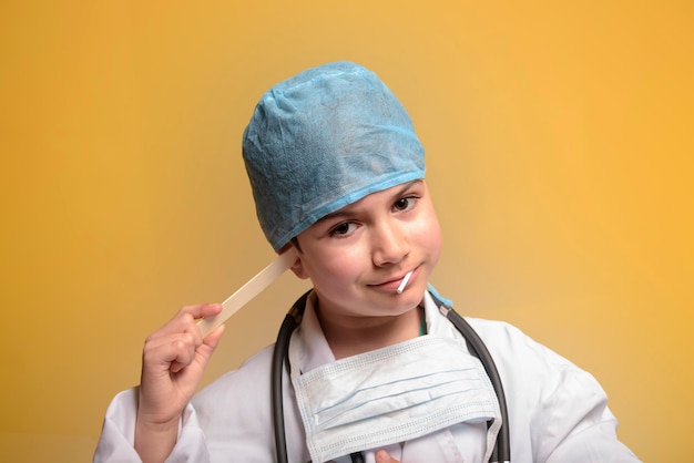 Adorable future doctor 7 years old boy isolated on yellow