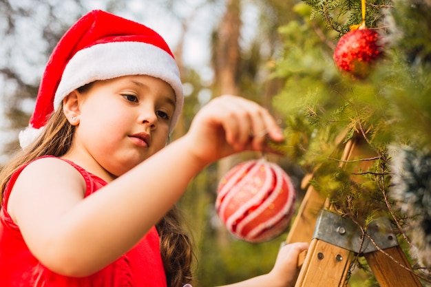 Adorable girl decorating the Christmas tree