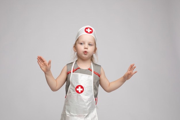 Foto adorabile ragazza in uniforme da dottore. è una dottoressa.