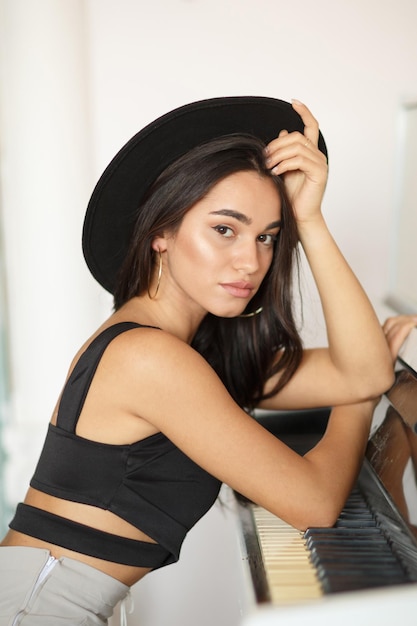 Adorable girl leaning on piano and looking at the camera High quality photo