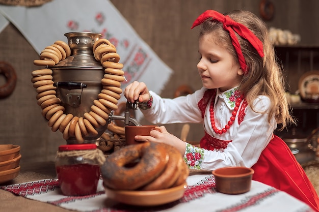 Adorable girl pouring tea from samovar