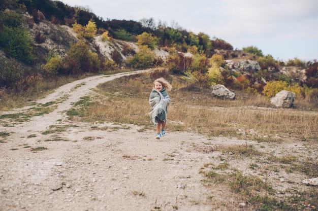 Adorable girl stay covered with  blanket in park