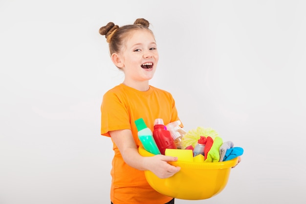 Adorable girl with a basin full of cleaners