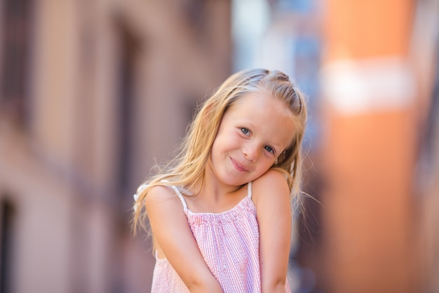 Adorable happy little girl outdoors in italian city. Portrait of caucasian kid enjoy summer vacation in Rome