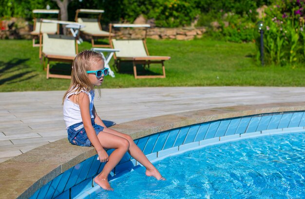 Adorable happy little girl in the swimming pool