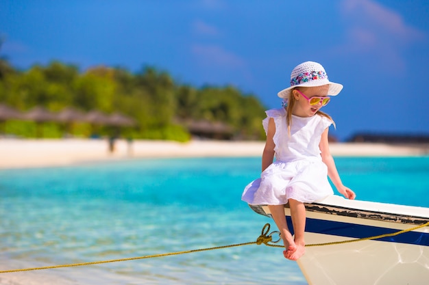 Очаровательны счастливой улыбкой маленькая девочка на лодке в море