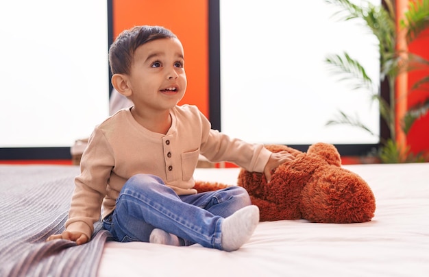 Adorable hispanic toddler smiling confident sitting on bed at bedroom