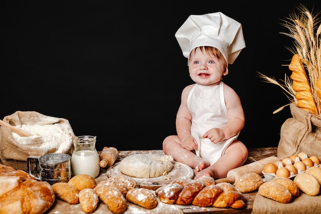 Adorable infant on table with dough