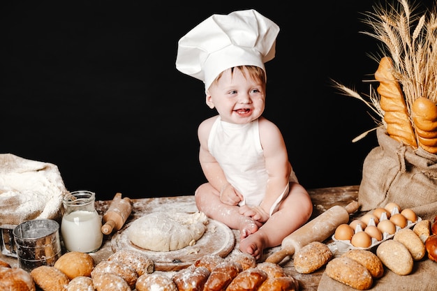 Adorable infant on table with dough
