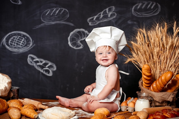 Adorable infant on table with dough