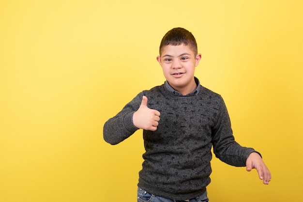 adorable kid in casual clothes standing and giving thumbs up.