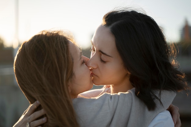 Adorable lesbian couple kissing outdoors